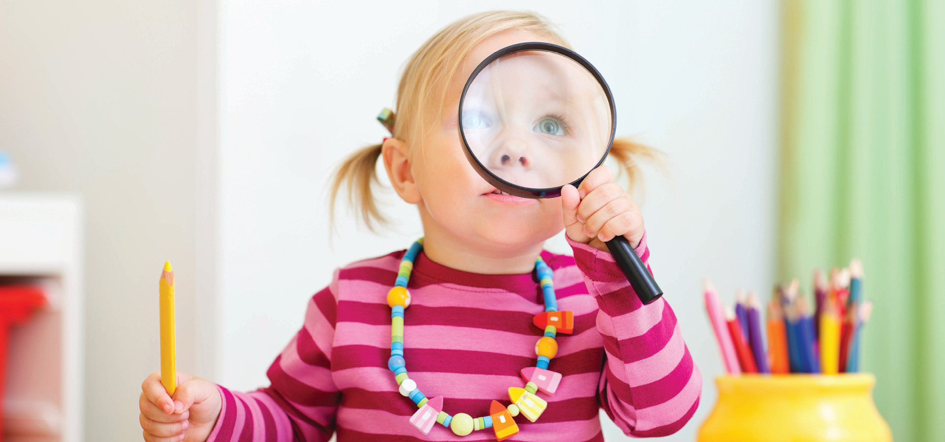 sunflower seed-  toddler girl looking through magnifier